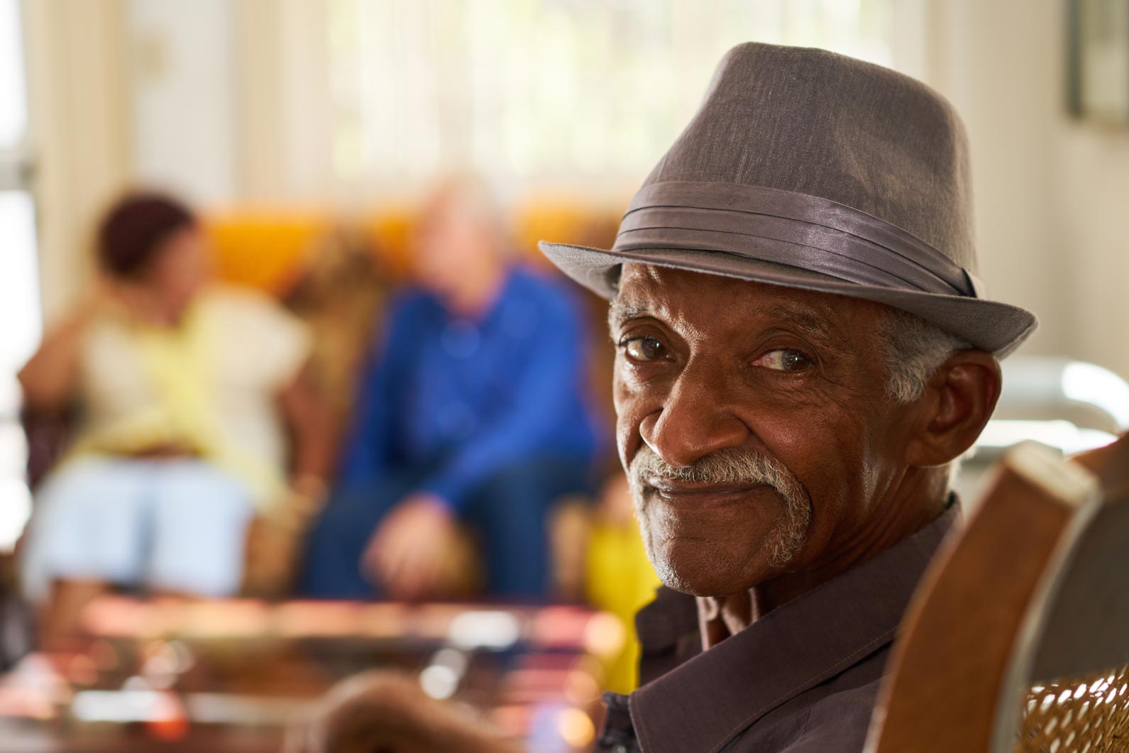 Old man in hat, who looks similar to an older Sammy Davis Jr., looking right at you.