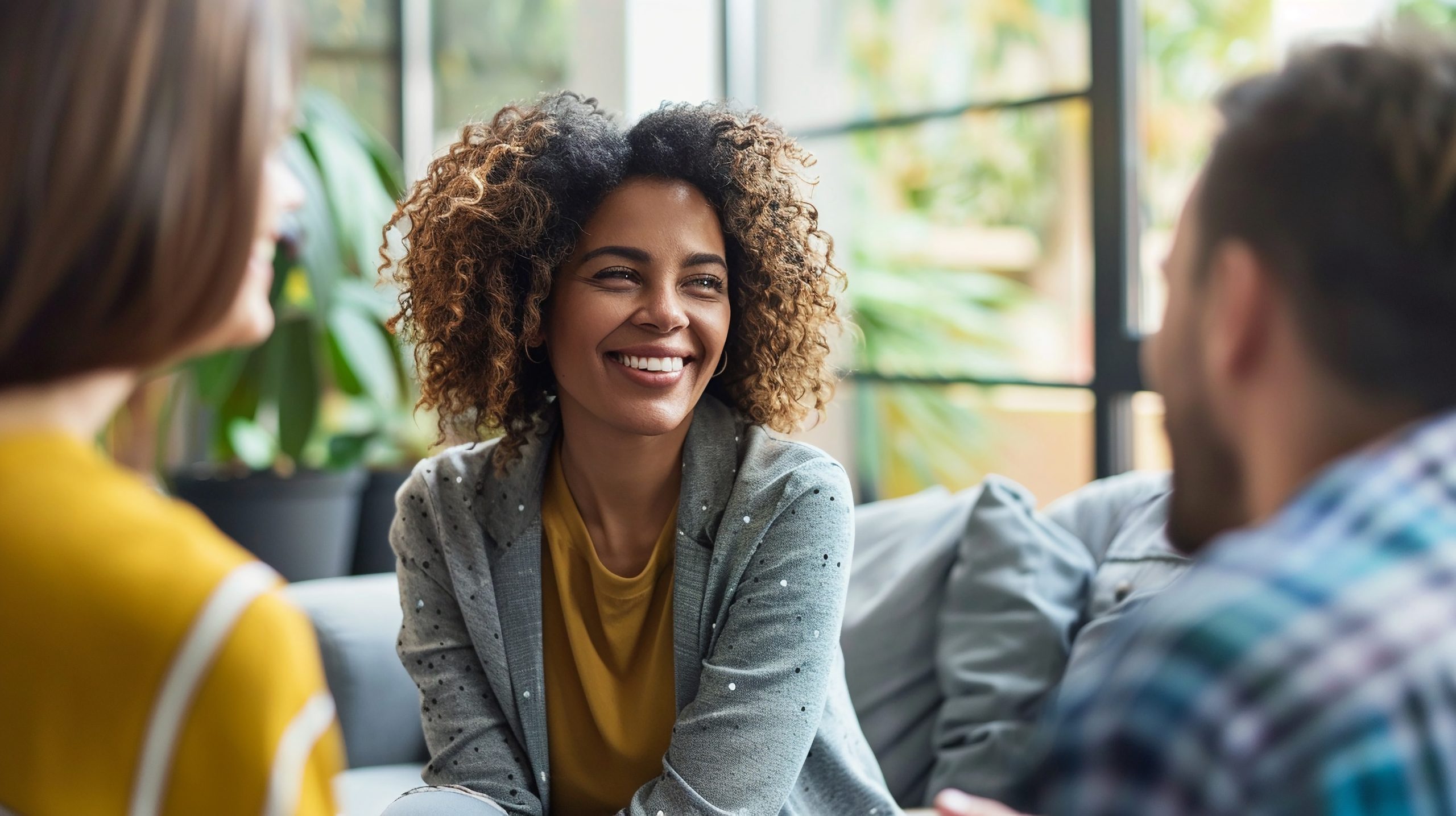 A counselor smiles at two people who site across from her